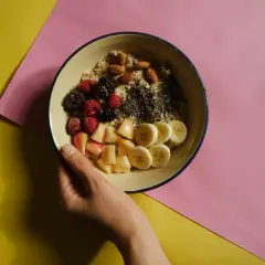 Miseczka owsianki z owocami i orzechami, idealna na śniadanie w ramach dieta bogatoresztkowa.