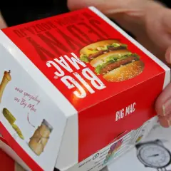 Ręce trzymają pudełko Big Maca z informacją o jego zawartości, w tym mcchicken kcal.