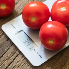 Czerwone pomidory na wadze cyfrowej. Waga pokazuje 34g. Idealne do liczenia pomidor kalorie.