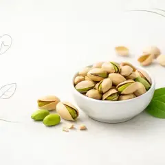 Miseczka pełna pistacji, które kuszą zielonym wnętrzem. Odkryj ich zdrowotne pistacje właściwości i ciesz się smakiem natury.