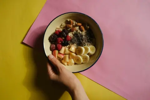 Miseczka owsianki z owocami i orzechami, idealna na śniadanie w ramach dieta bogatoresztkowa.