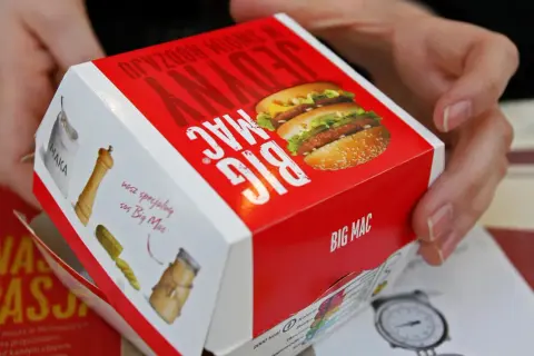 Ręce trzymają pudełko Big Maca z informacją o jego zawartości, w tym mcchicken kcal.