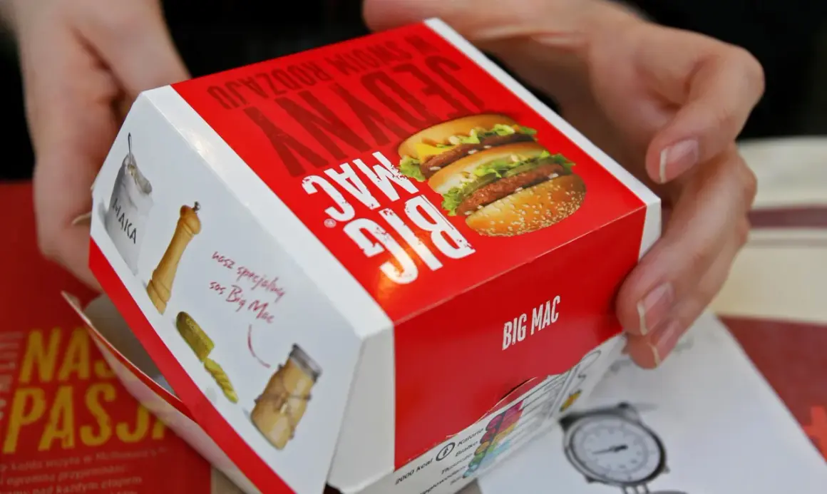 Ręce trzymają pudełko Big Maca z informacją o jego zawartości, w tym mcchicken kcal.